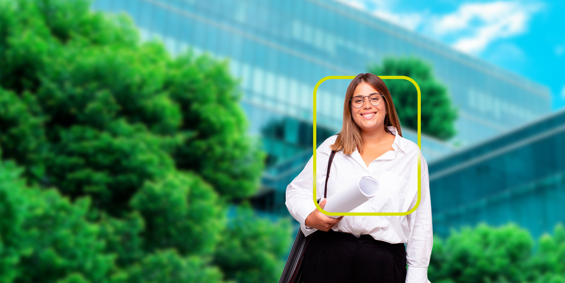 Uma mulher de pele branca, sorridente, com cabelos castanhos e óculos está segurando um conjunto de plantas ou desenhos arquitetônicos. Ela veste uma blusa clara e calças escuras. Ao fundo, desfocado, vê-se um prédio moderno com muitas janelas e vegetação.