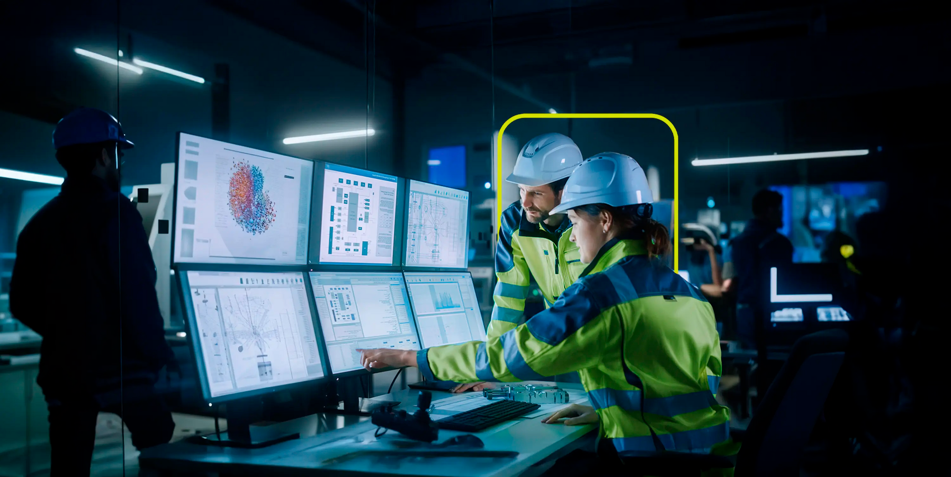 Uma foto em tons de azul e amarelo de dois trabalhadores industriais usando capacetes e coletes de segurança, olhando para equipamentos em uma fábrica ou instalação industrial. O foco está ligeiramente suave no fundo, com os trabalhadores mais nítidos.