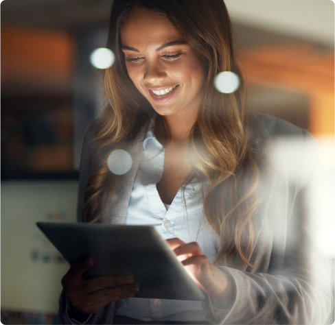 Uma jovem mulher sorridente, usando um tablet.